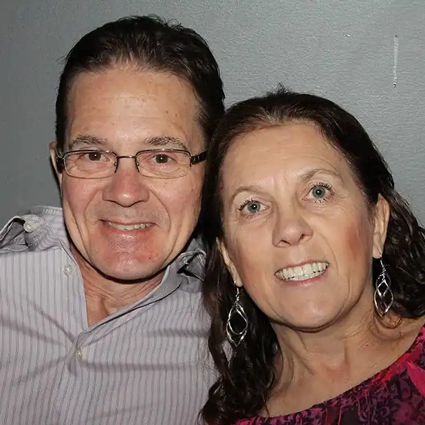 Smiling couple posing together for a close-up portrait indoors.